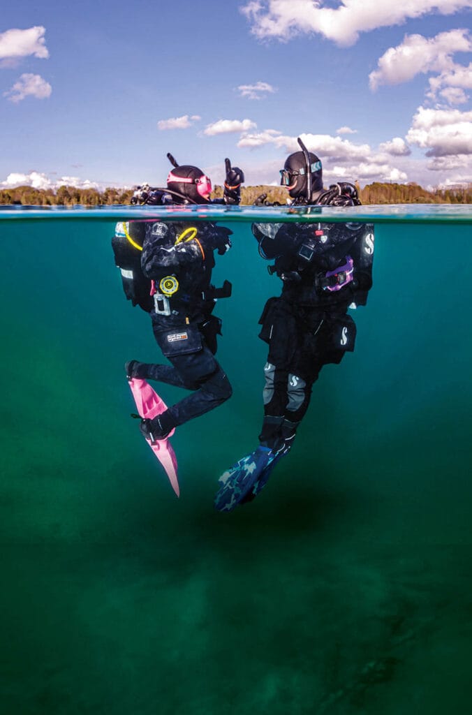 Advanced drysuit scuba divers descending in cold water. Vancouver